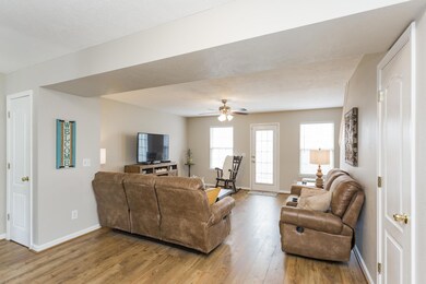 View into the living area, made homey with updated wide plank vinyl floors and ceiling fan.