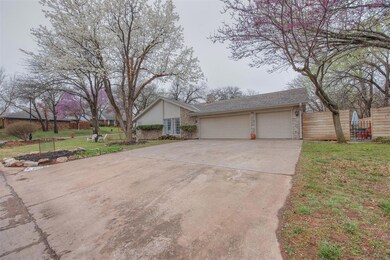 Ranch-style home featuring a garage and a front ya