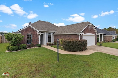 Single story home featuring brick siding, roof with shingles, driveway, and a garage