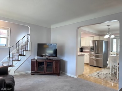 Living room with light carpet and a notable chandelier