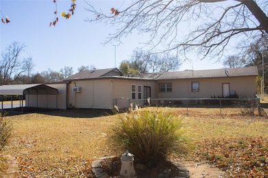 Back of house featuring a detached carport