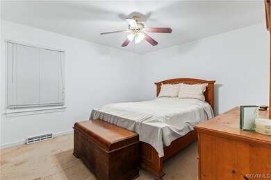 Carpeted bedroom featuring ceiling fan
