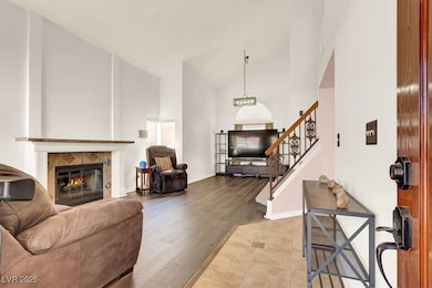 Front formal living and dining area with a centered fireplace and soaring vaulted ceilings.