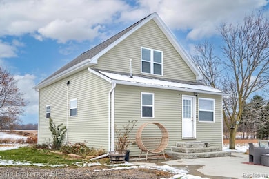Snow covered rear of property featuring a shingled roof and entry steps