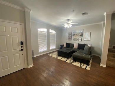 Living room featuring wood finished floors, crown