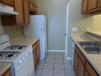 Kitchen featuring white gas stove, under cabinet 