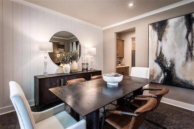 Dining space with ornamental molding and dark wood