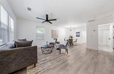 Living room with ceiling fan with notable chandeli