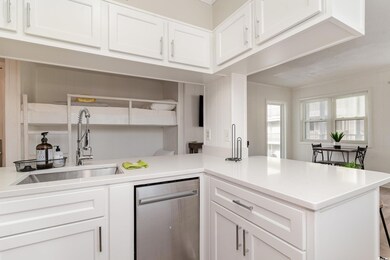 Kitchen featuring white cabinetry, kitchen peninsu