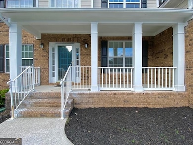 View of exterior entry featuring brick siding and covered porch