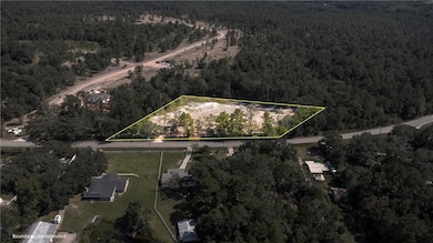 Aerial view of property and surrounding area featuring a forest and property parcel outlined