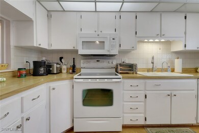 Kitchen with tasteful backsplash, white appliances