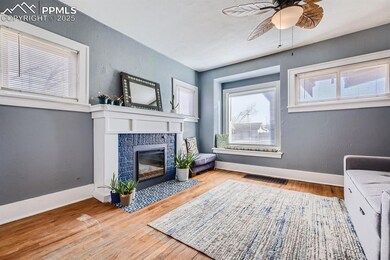 Sitting room featuring ceiling fan, a fireplace, a