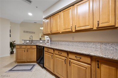 Kitchen with light tile patterned floors, black dishwasher, a peninsula, light stone countertops, and recessed lighting