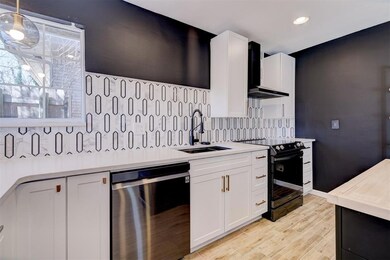 Kitchen featuring black electric range, light coun