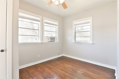 This room features hardwood floors, three large wi