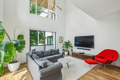 The adjacent Great Room impresses with its Atrium-Style Ceiling, sleek modern accents, and direct access to the Large Rear Porch.