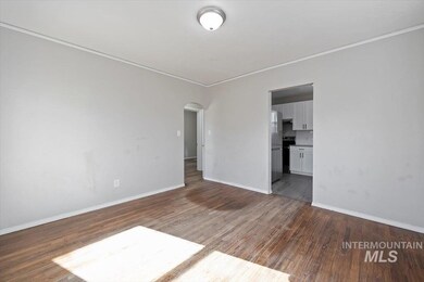 Unfurnished room with arched walkways, crown molding, and dark wood-type flooring