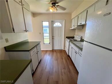 Kitchen featuring white cabinets, white appliances