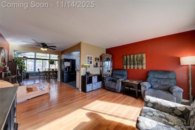 Living room with light wood-style flooring and a ceiling fan