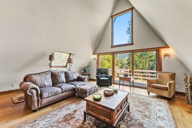 Living room featuring wood finished floors, high vaulted ceiling, and a skylight