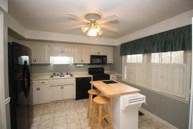 Bright and cheery kitchen  with  range, dishwasher, microwave, refrigerator and disposal.