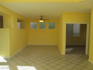 Empty room featuring ceiling fan and light tile patterned flooring