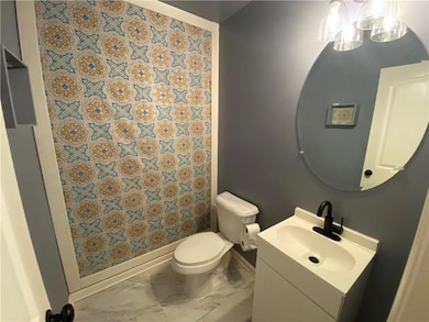 Full bath with a shower with shower curtain, vanity, and marble finish flooring