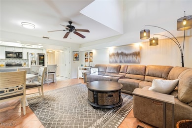 Living area with light tile patterned floors and ceiling fan