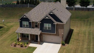 Craftsman inspired home featuring board and batten siding, brick siding, an attached garage, and concrete driveway