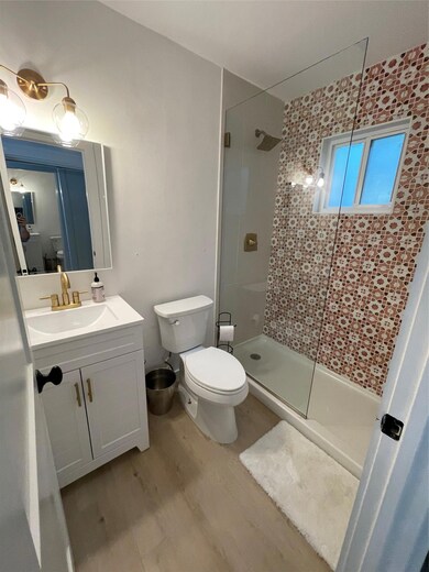 Full bath featuring wood finished floors, a stall