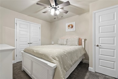 Carpeted bedroom featuring a closet and ceiling fan