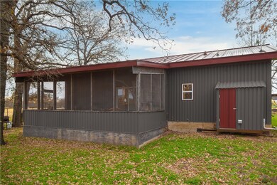 View of side of home with a lawn and a sunroom