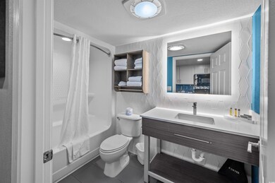 Full bathroom featuring tile patterned flooring, toilet, shower / bathtub combination with curtain, a textured ceiling, and tasteful backsplash