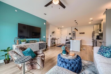 Living area featuring ceiling fan, light wood-sty