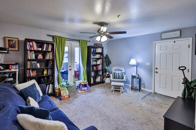 Carpeted living area featuring a textured ceiling, french doors, and a NEW ceiling fan