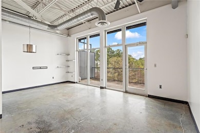Unfurnished room featuring baseboards and concrete