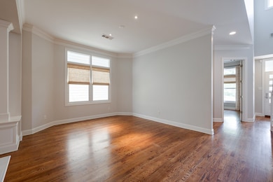 Empty room with crown molding, wood finished floor