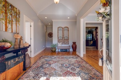 A Welcoming Foyer boasts a Vaulted Ceiling, decorative Trim Package, Hardwoods floor through the Entry, Dining Room, Master Bedroom, Bedroom 2 and Bedroom 3.