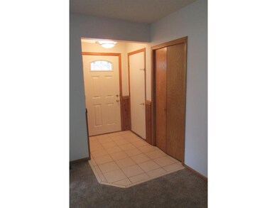 Tile front entry just off the garage entry door wi