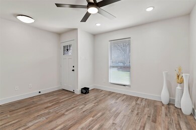 Living room with wood-style flooring, baseboards, 
