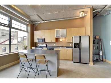 Kitchen features light cabinets, dark counters and