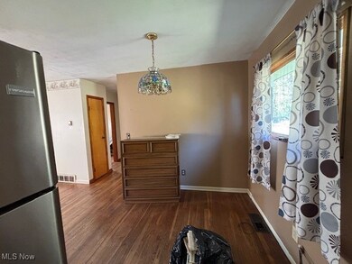 Dining room with dark wood-type flooring and baseboards