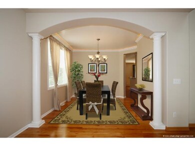 Formal Dining Room with arch, columns, wood floors