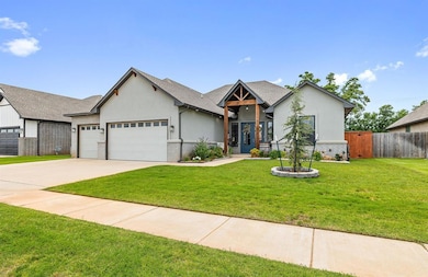 View of front of property featuring an attached garage, stucco siding, driveway, and brick siding