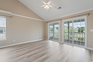 Spare room featuring ceiling fan, vaulted ceiling, baseboards, light wood finished floors, and crown molding