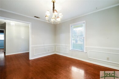 Formal dining room has wood floors, decorative mol
