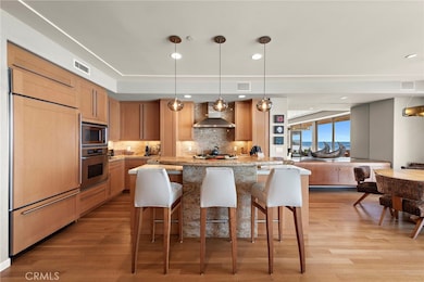 Gourmet kitchen complete with high end stainless appliance package including 6 burner gas range, granite counters with island and breakfast bar, and bar with sub-zero wine fridge.