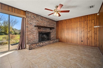 Family room featuring a large brick fireplace, and ceiling fan