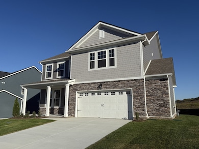 The front of the home features stone, shaker siding and Hardie siding to create a gorgeous exterior design for beautiful curb appeal.